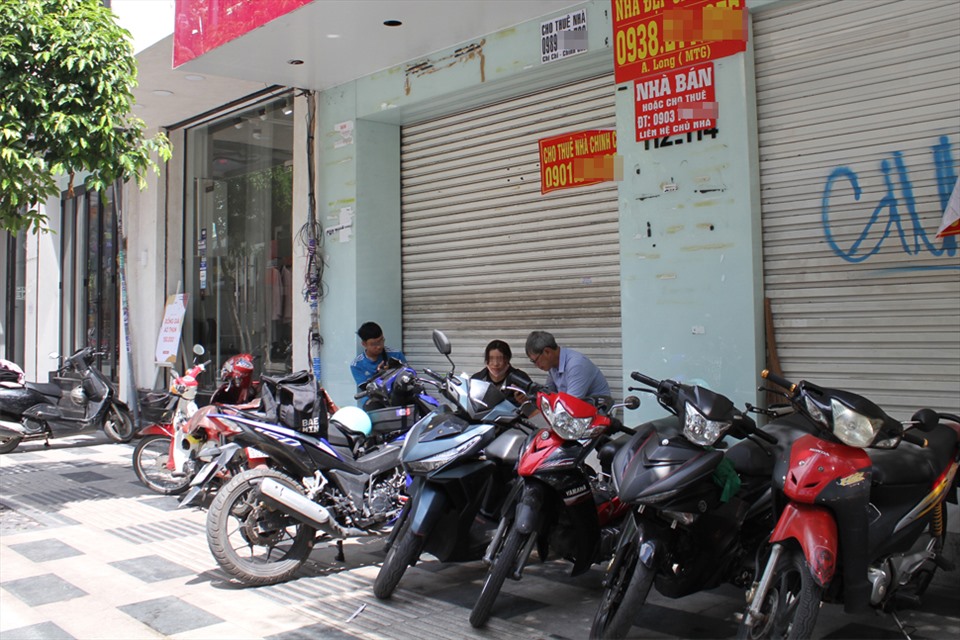 Nhiều người tận dụng vỉa hè của các cửa hàng đã đóng cửa ở đường Nguyễn Trãi, Quận 1 để làm khu vực giữ xe cho khách đến mua sắm ở những cửa hàng xung quanh. Ảnh: T.V