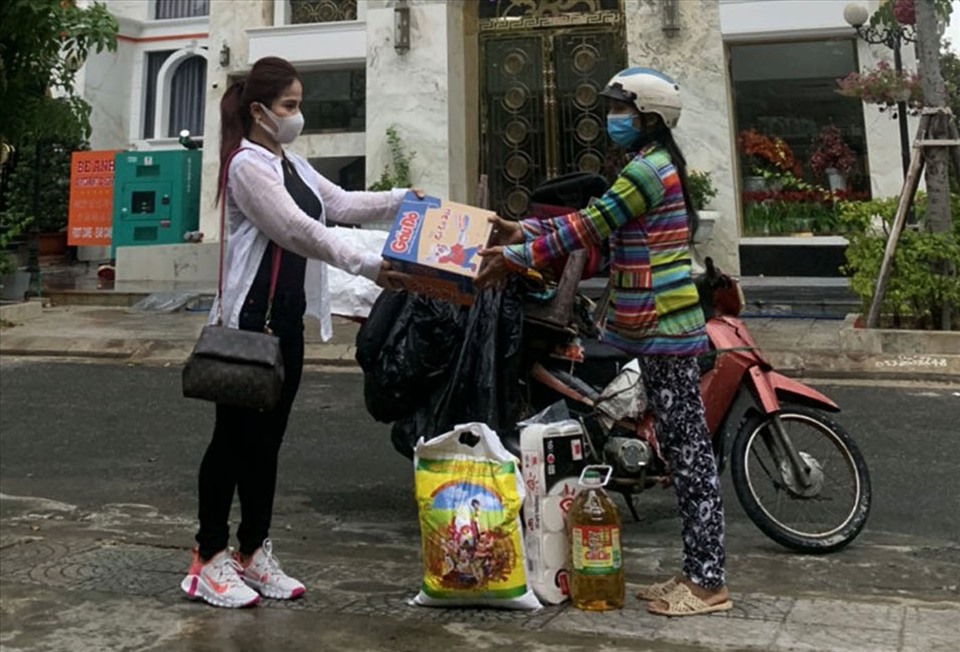 Bà Đinh Thị Anh (trái) tặng quà người nghèo trong mùa dịch COVID-19. Ảnh: Lê Văn Thơm.