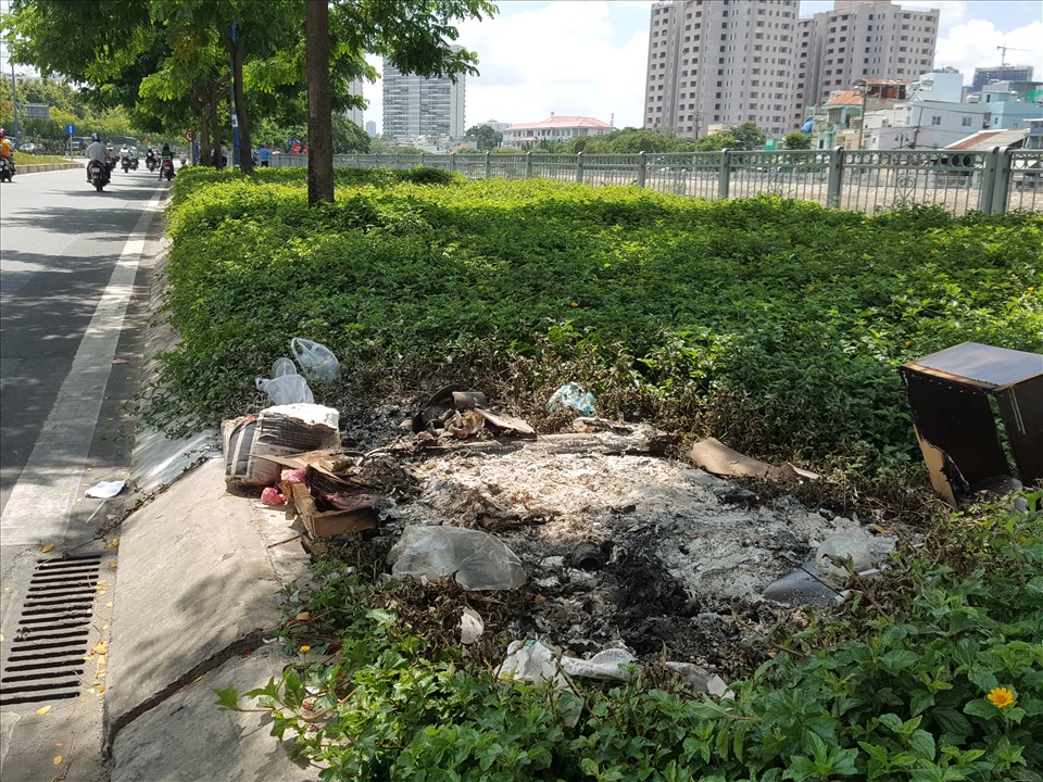 Người dân đốt rác ở khu vực mảng xanh trên đường Võ Văn Kiệt (đoạn phía dưới cầu Nguyễn Tri Phương, quận 5, TPHCM). Ảnh: An Nguyên