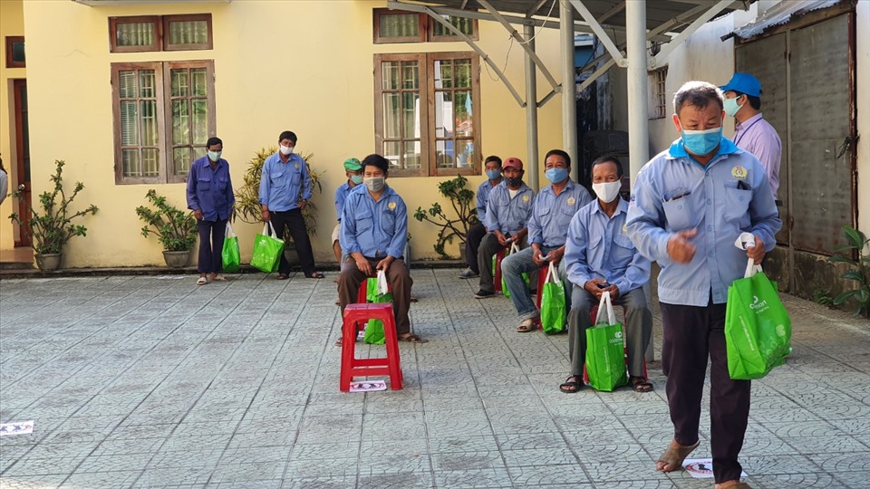 Những người đến nhận gạo giữ gìn khoảng cách, đảm bảo an toàn phòng chống dịch. Ảnh: PĐ.