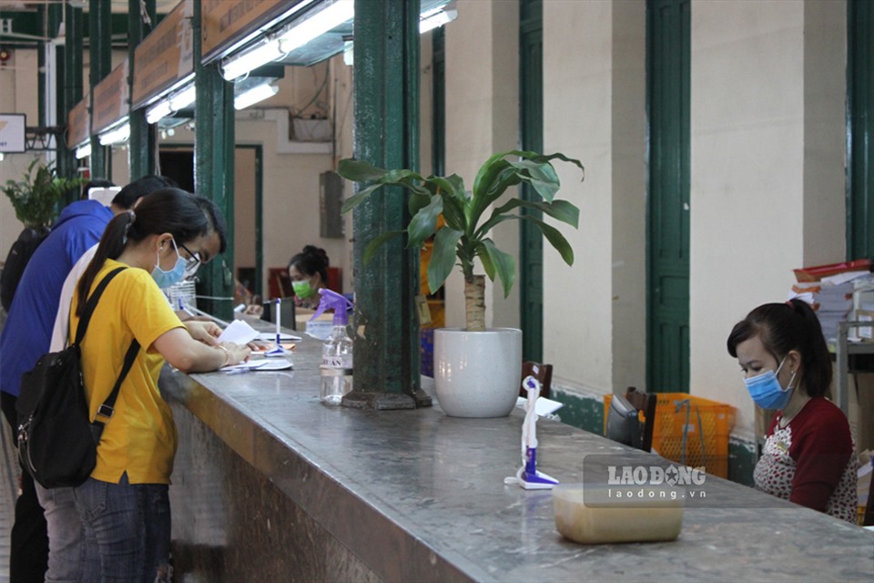 Nhân viên giao dịch và khác hàng tại bưu điện thành phố Hồ Chí Minh chấp hành nghiêm túc việc đeo khẩu trang. Ảnh: Thanh Vũ
