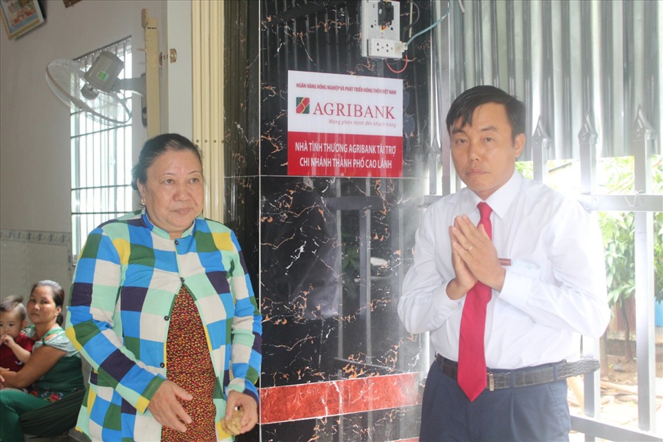 Ông Nguyễn An Bình, Giám đốc Agribank chi nhánh TP Cao Lãnh gắn biển ngôi nhà. Ảnh: Trung Hiếu