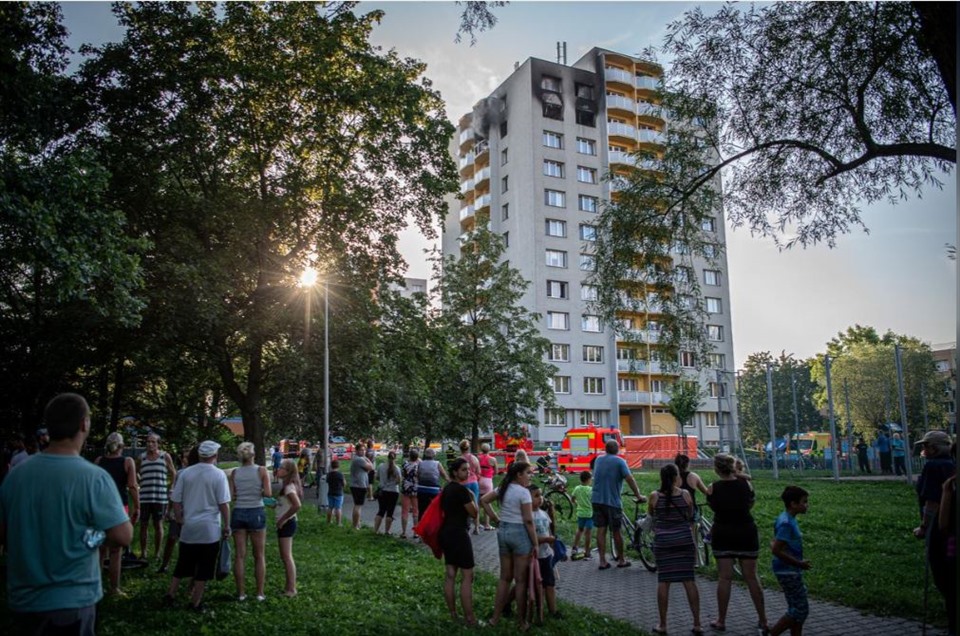Người dân đứng quan sát dưới chân tòa chung cư bị cháy hôm 8.8 ở thị trấn Bohumin, Cộng hòa Czech. Ảnh: Reuters