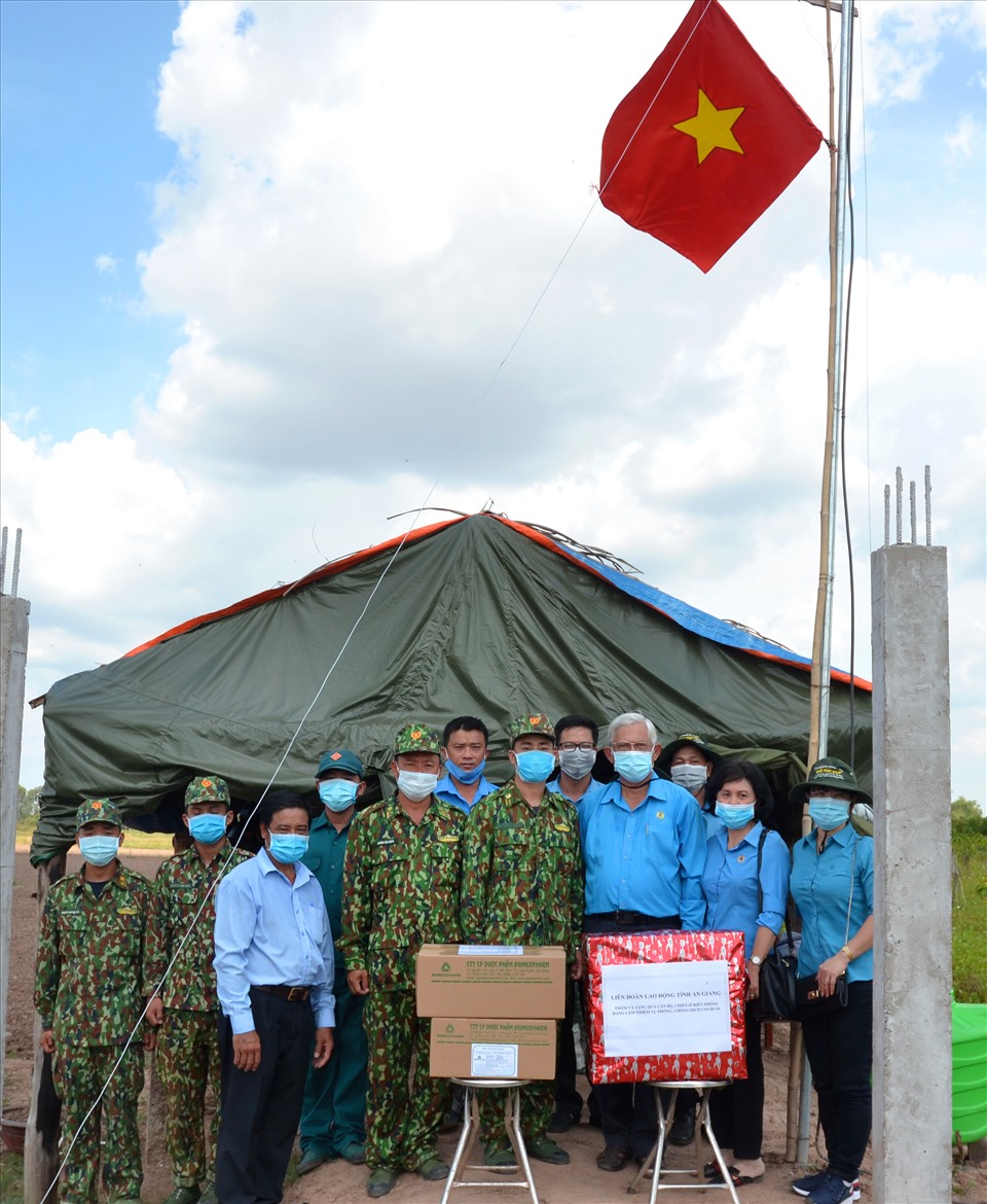 Chung tay dưới ngọn cờ hồng Tổ quốc, hình ảnh thể hiện quyết tâm của tổ chức Công đoàn An Giang chung việc góp sức tạo ra rào chắn dịch bệnh vững chắc trên tuyến biên giới. Ảnh: Lục Tùng