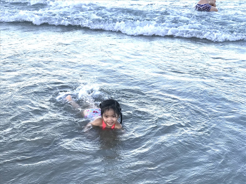 Hình ảnh một em nhỏ thoải mái chơi dưới biển sau nhiều ngày không được tắm biển. Ảnh: Mai Hương