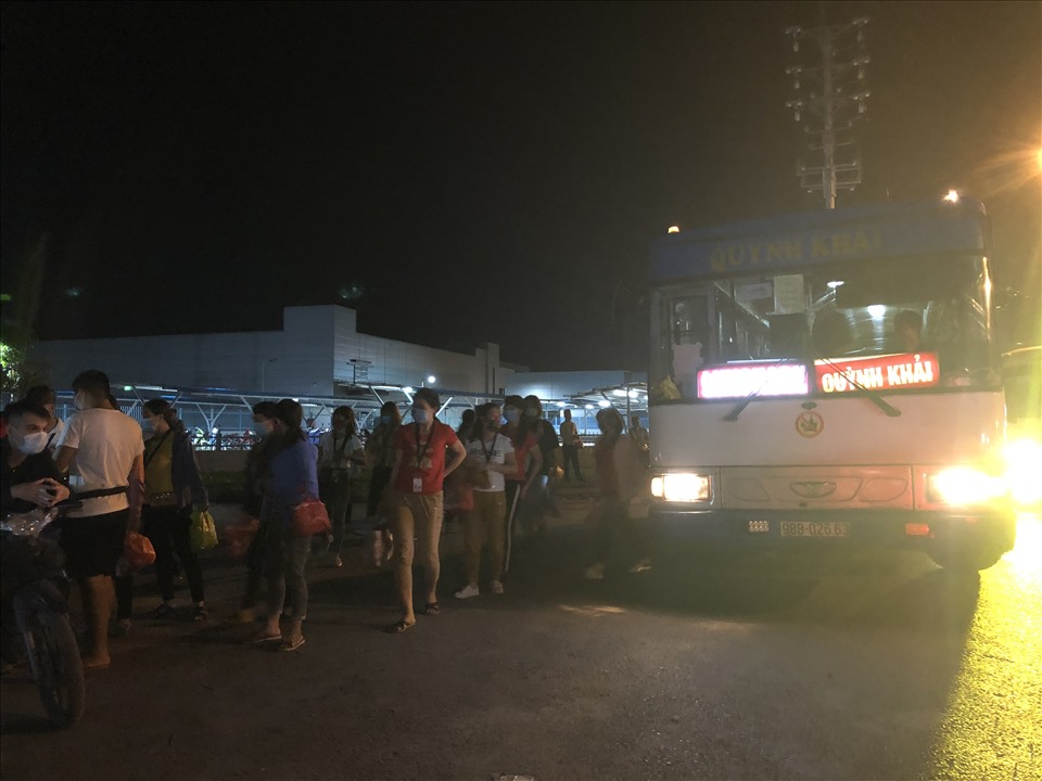 Công nhân Công ty TNHH Luxshare - ICT (Vân Trung) rời xe bus để đến công ty làm ca đêm. Ảnh chụp lúc 19 giờ ngày 14.9. Ảnh: Bảo Hân.
