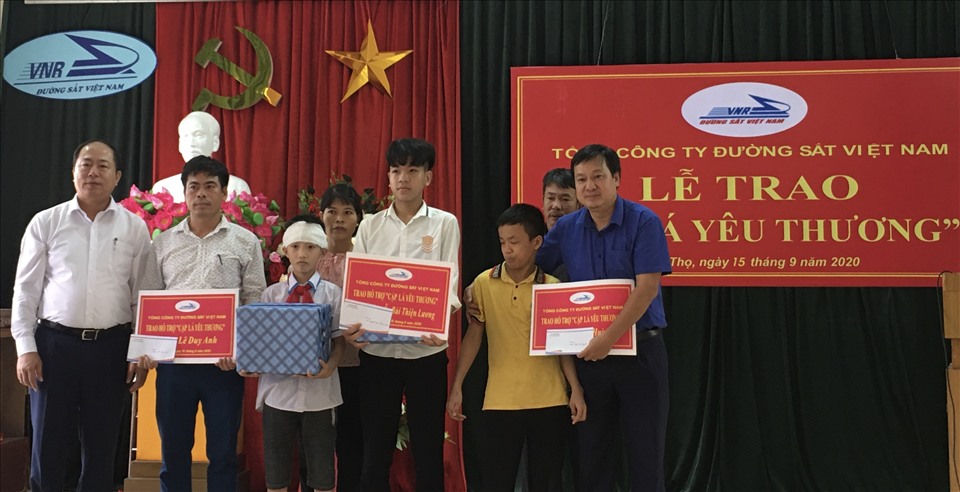 Ông Vũ Anh Minh -  Chủ tịch Hội đồng thành viên TCty Đường sắt Việt Nam, (ngoài cùng bên trái)  trao biển hỗ trợ “Cặp lá yêu thương”. Ảnh: Hải Anh