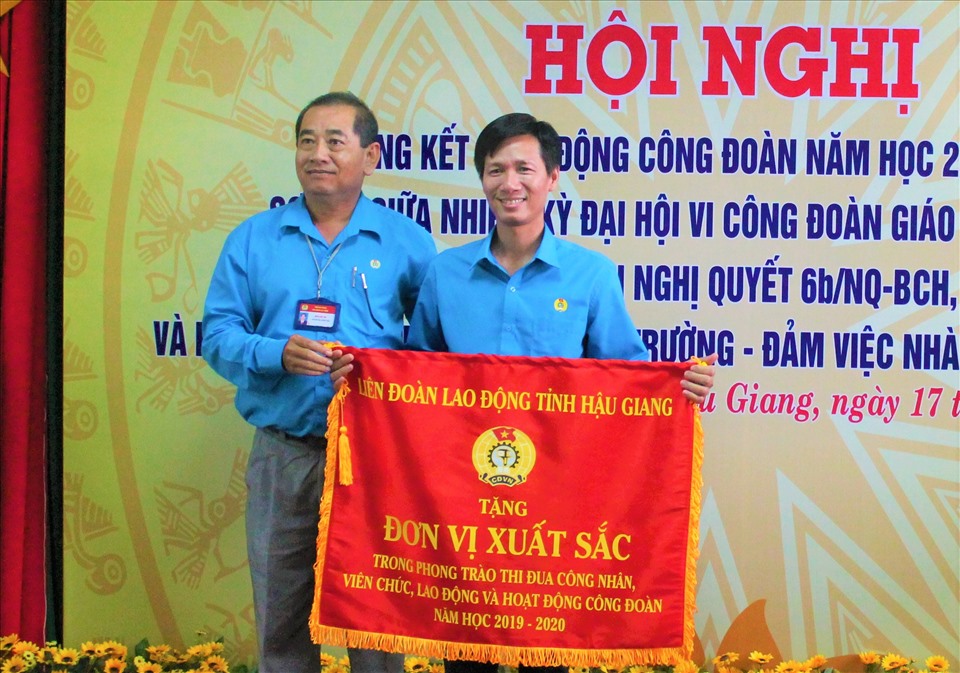 Ông Kiều Văn Thọ - Phó Chủ tịch LĐLĐ tỉnh Hậu Giang trao cờ thi đua cho CĐCS Trường THPT Vị Thủy. Ảnh: Thành Nhân