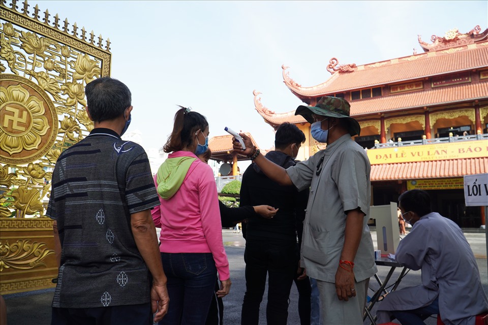 Tại Việt Nam Quốc Tự (Quận 10, TPHCM) người dân trước khi vào bên trong đều phải xếp hàng để đo thân nhiệt.