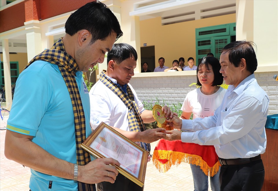 Chủ tịch LĐLĐ tỉnh Đồng Tháp trao tặng biểu trưng của tỉnh và Bằng khen của UBND tỉnh cho đơn vị tài trợ. Ảnh: Lưu Hùng