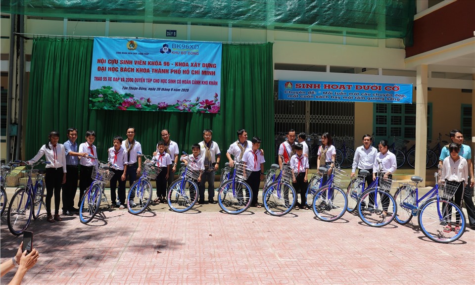 Chủ tịch LĐLĐ tỉnh Đồng Tháp Trần Hoàng Vũ và Hội cựu sinh viên Khóa 96 Khoa Xây dựng, Đại học Bách khoa TPHCM trao xe đạp cho học sinh. Ảnh: Lưu Hùng