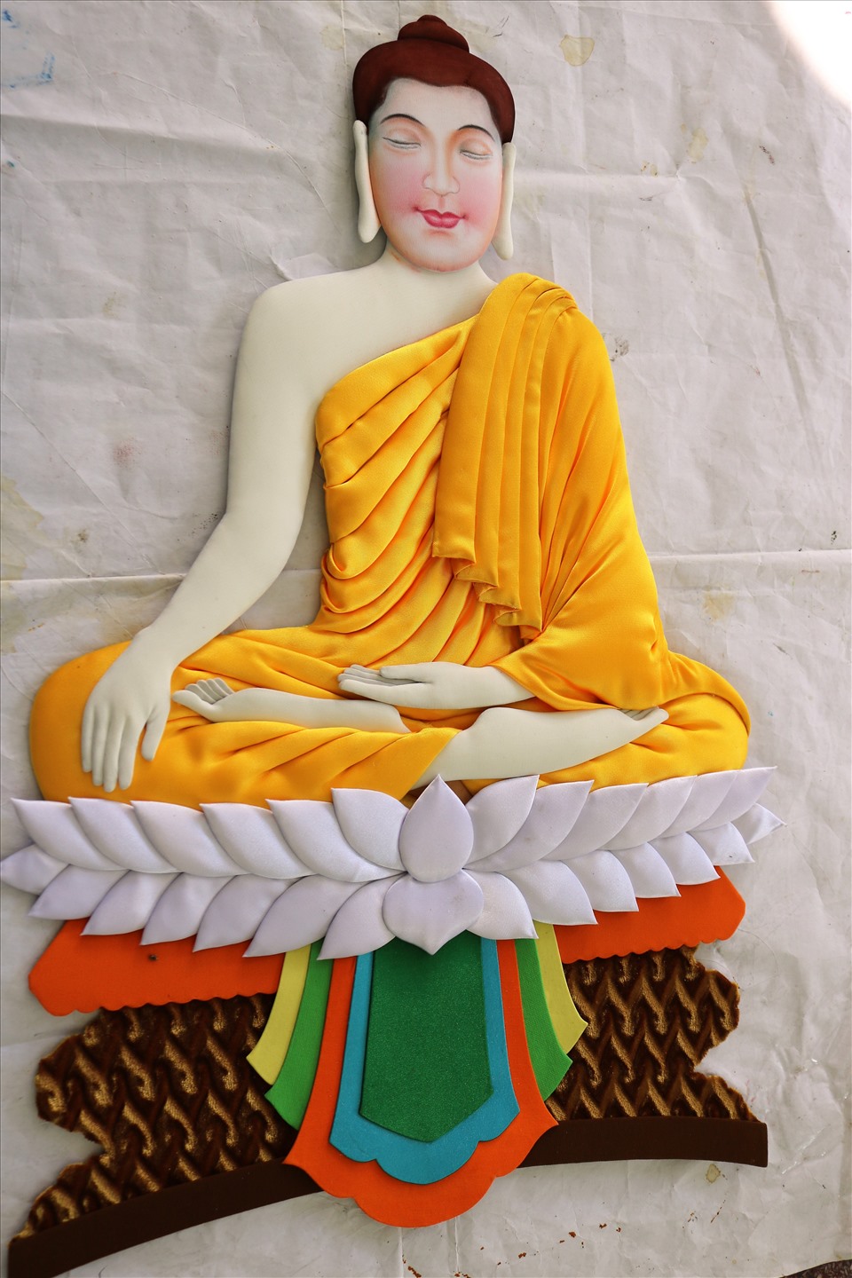 Tranh gói vải chân dung Phật được tạo hình hoàn chỉnh từ đôi tay khéo léo của nghệ ông Tai.