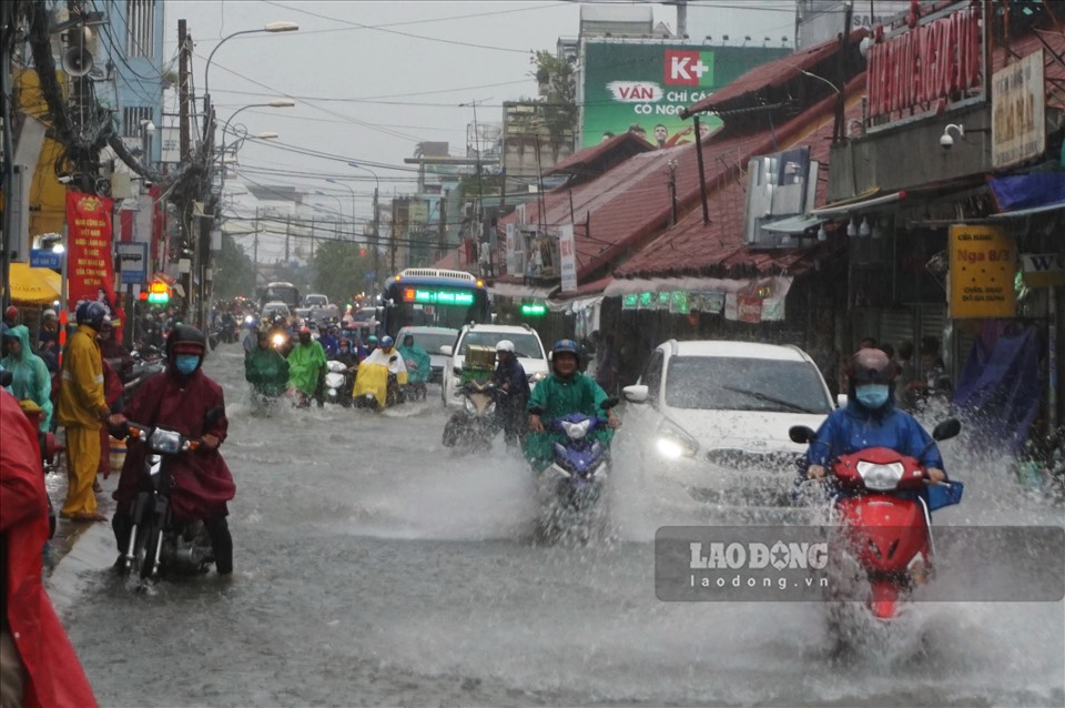 Xung quanh chợ Thủ Đức ngập như sông khiến người dân đi lại khó khăn.  Ảnh: Minh Quân