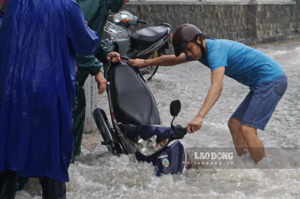 Xe máy người dân bị sụp hố ga trên đường Võ Văn Ngân trong mưa lớn chiều ngày 24.9. Ảnh: Minh Quân
