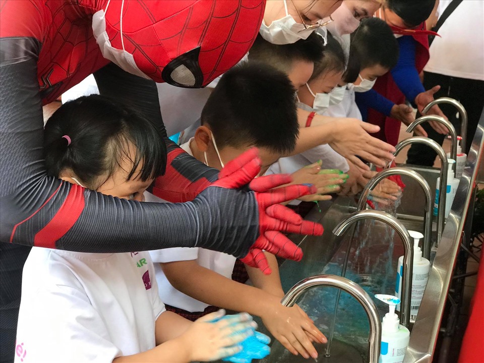 Siêu nhân nhện hướng dẫn các em nhỏ Trường Mầm non 1 - 6 rửa tay đúng 6 bước. Ảnh: Thanh Hà