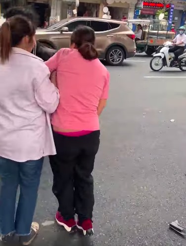 Thai phụ được người dân dìu đi sau pha va chạm giao thông với nhóm thanh niên manh động. Ảnh: Cắt từ clip.