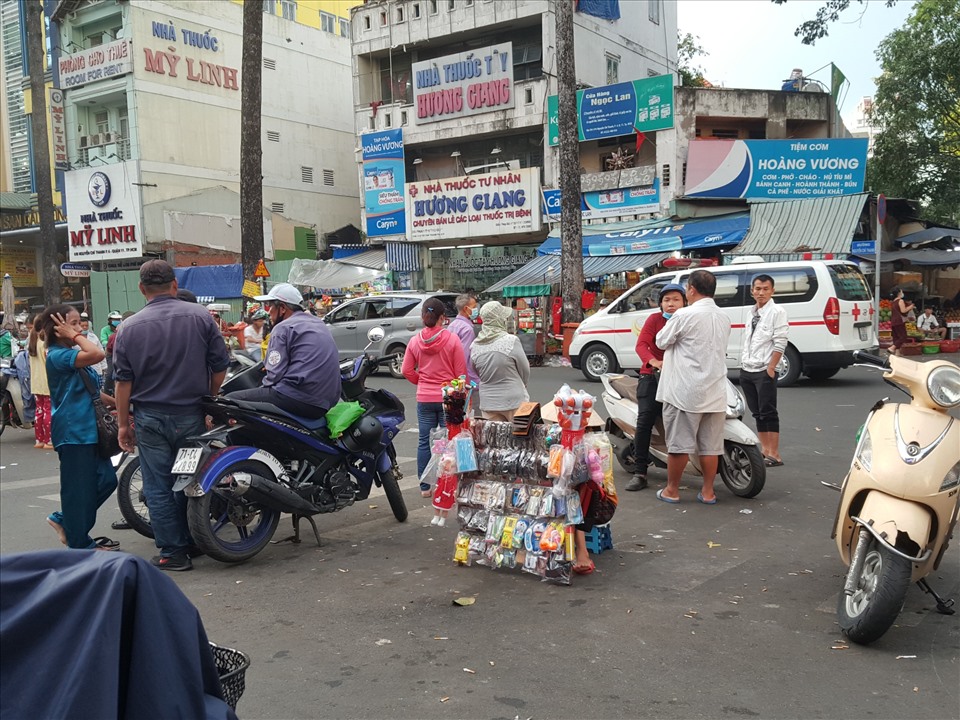 Nhiều người bán hàng rong, tài xế xe ôm dừng đỗ phía trước cổng bệnh viện để kinh doanh, đón khách. Ảnh: Nguyễn Huy