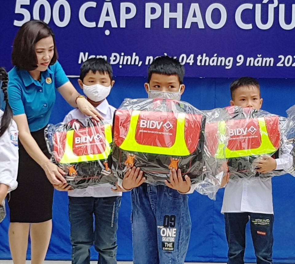 Bà Bùi Ánh Nguyệt, Phó chủ tịch LĐLĐ tỉnh Nam Định trao cặp phao cho học sinh Trường Tiểu học Thọ Nghiệp. Ảnh: NT