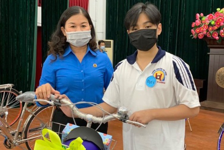 Bà Lê Thị Bích hạnh, Chủ tịch LĐLĐ Quận 5, trao xe đạp cho con CNVCLĐ có hoàn cảnh khó khăn làm phương tiện đi học. Ảnh Đức Long