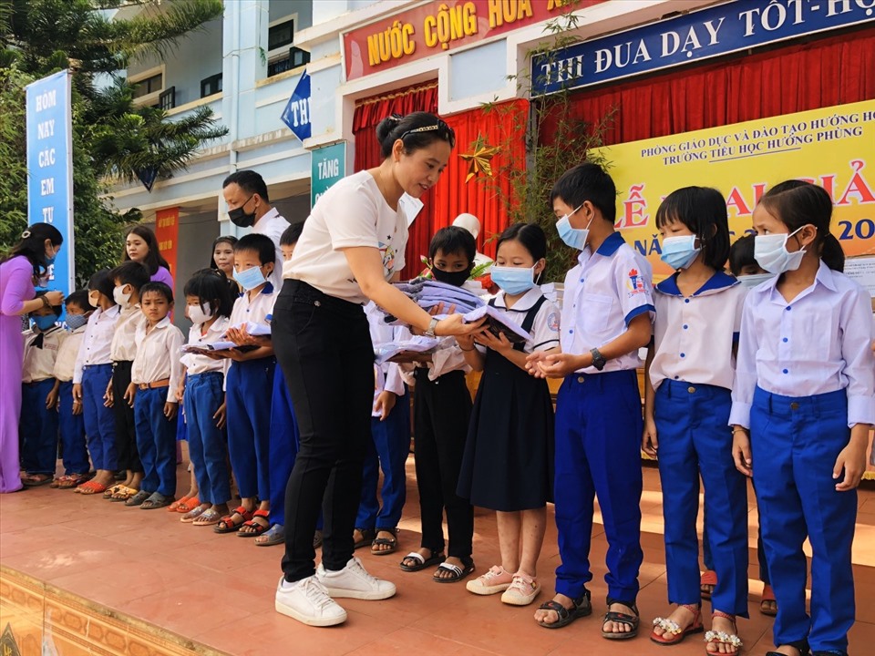 Các Mạnh Thường Quân trao quà cho học sinh Trường Tiểu học Hướng Phùng trong ngày khai giảng năm học mới. Ảnh: HH.