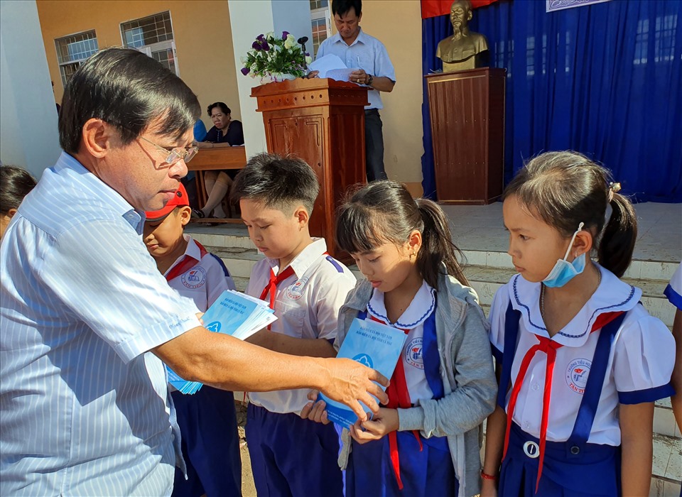 Ông Đặng Trung Kiên, Giám đốc Bảo hiểm xã hội Cà Mau trao học bổng cho học sinh (ảnh Nhật Hồ)
