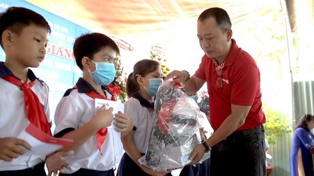 Ông Trần Khánh Vũ - Phó Giám đốc CN Tp. Hồ Chí Minh (thuộc Vietlott) trao tặng các suất học bổng cho các em học sinh khó khăn tại Trường tiểu học An Nhơn Tây. Ảnh BH