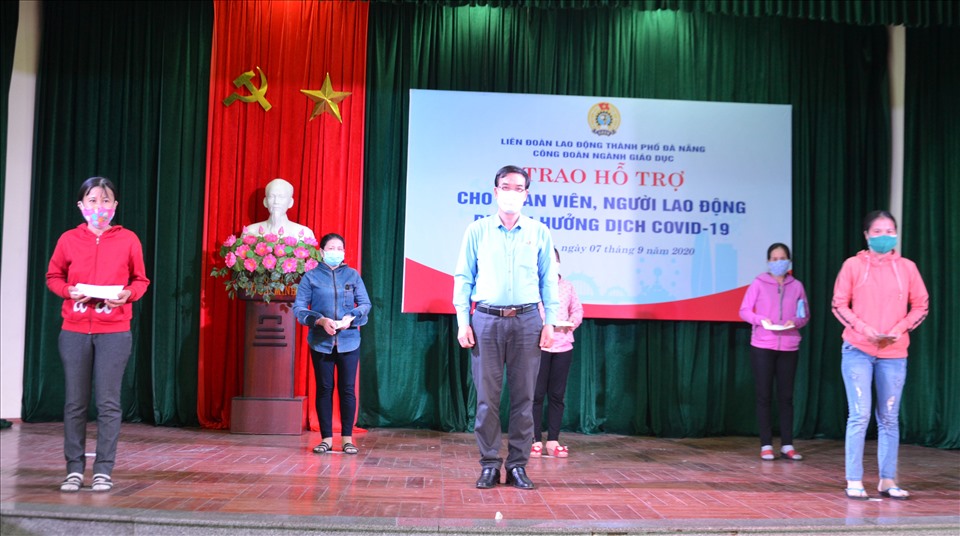 Ông Hoàng Hữu Nghị - Chủ tịch LĐLĐ TP Đà Nẵng (đứng giữa) trao hỗ trợ cho đoàn viên bị ảnh hưởng dịch COVID-19. Ảnh Ngọc Phú