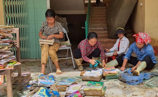 Sách giáo khoa của học sinh ở Lào Cai bị nước bùn đất vùi lấp, phải rửa lại để sử dụng.