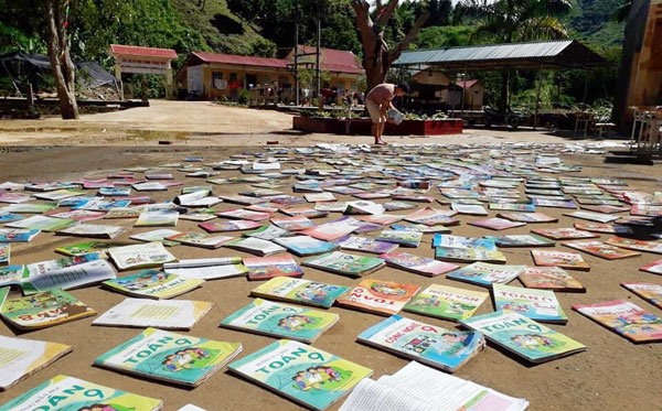 Sách giáo khoa của học sinh ở Lào Cai bị nước bùn đất vùi lấp, phải rửa lại để sử dụng.