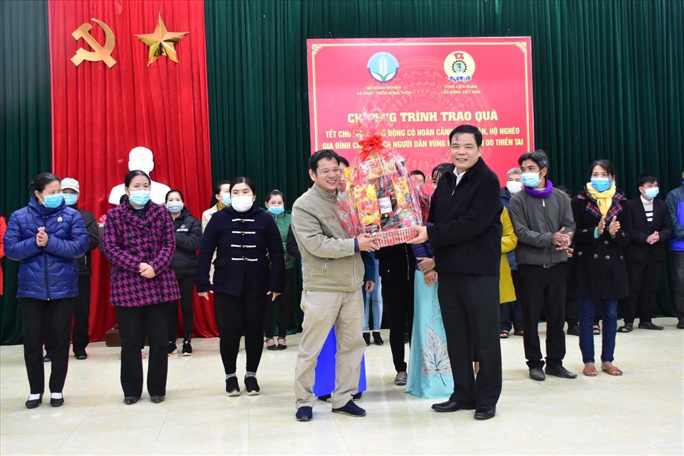 Bộ trưởng Bộ Bộ NN&PTNT Nguyễn Xuân Cường (phải)  tặng quà cho người dân. Ảnh: NH.