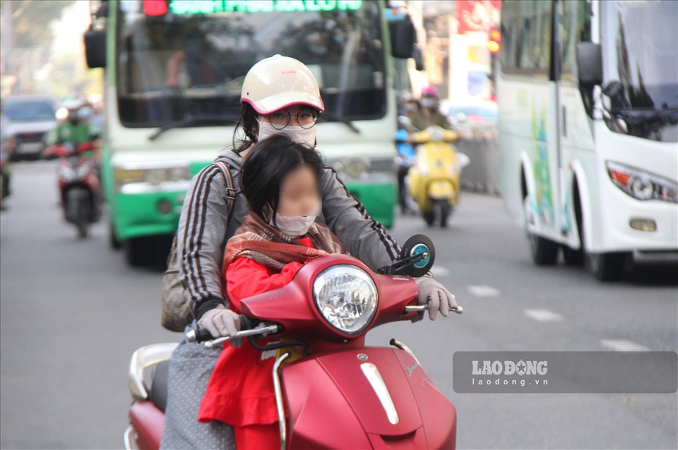 Nhiều người khi đang lưu thông trên đường phải dừng lại mang thêm bao tay và choảng khăn cho trẻ để giữ ấm.