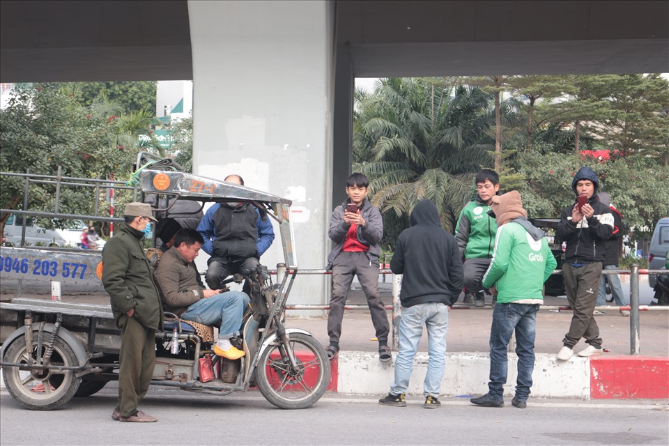 Thời điểm cuối năm, người làm nghề tự do “đứng ngồi không yên” chờ người thuê làm việc tại chợ người (dưới chân cầu đầu đường Hoàng Quốc Việt tiếp giáp đường Bưởi)