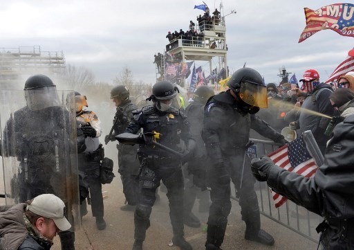 Một người biểu tình tấn công cảnh sát bằng bình xịt hóa học. Ảnh: AFP