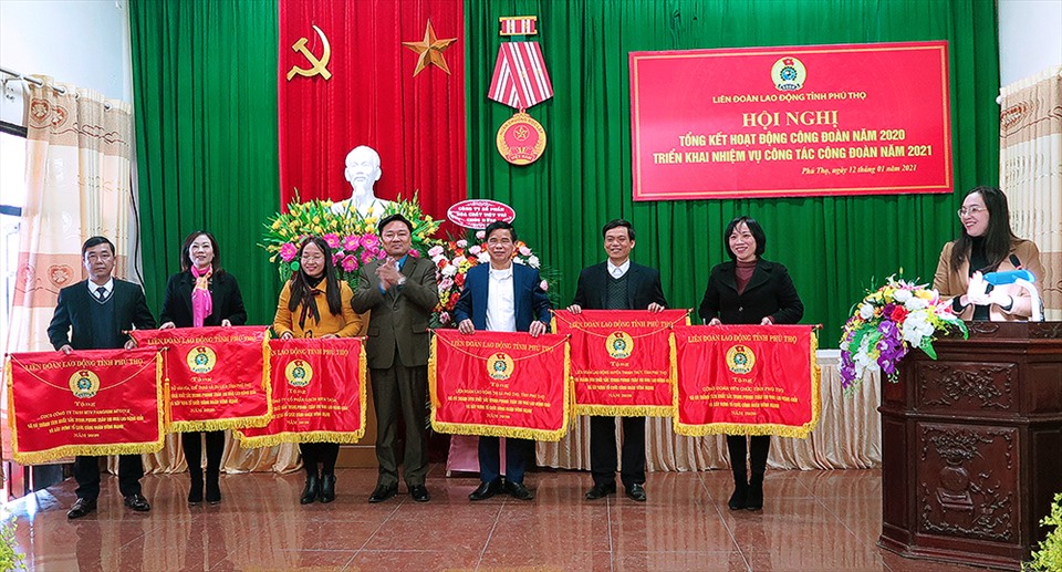 Ông Hà Đức Quảng - Chủ tịch LĐLĐ tỉnh trao cờ thi đua của LĐLĐ tỉnh cho các đơn vị đạt thành tích xuất sắc trong năm 2020. Ảnh: Hải Nguyễn