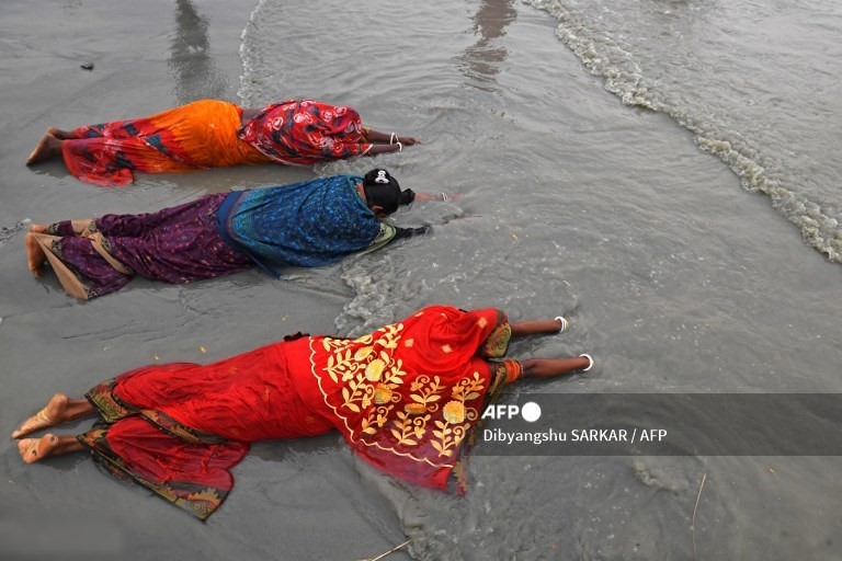 Những người hành hương theo đạo Hindu cầu nguyện tại nơi hợp lưu của sông Hằng và vịnh Bengal trong lễ Gangasagar Mela vào dịp lễ Makar Sankranti, một ngày được coi là có ý nghĩa tôn giáo lớn trong thần thoại Hindu, tại đảo Sagar, cách Kolkata khoảng 150 km về phía nam vào tháng Giêng. Ngày 14 năm 2021.
