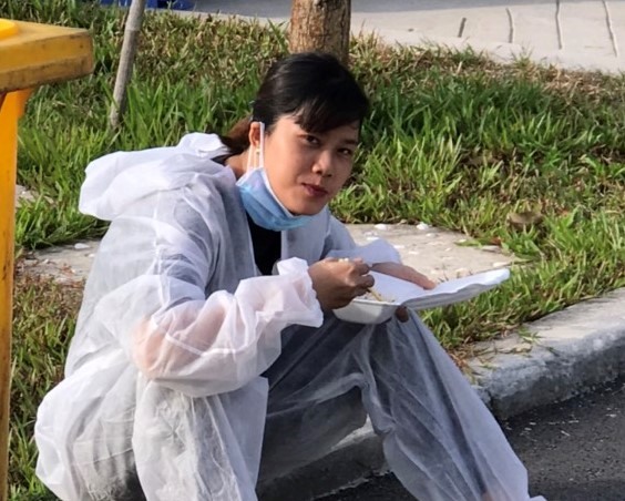 Nữ y tá Thu Trang tranh thủ ăn cơm hộp để đón công dân về cách ly. Ảnh: TTYTBB