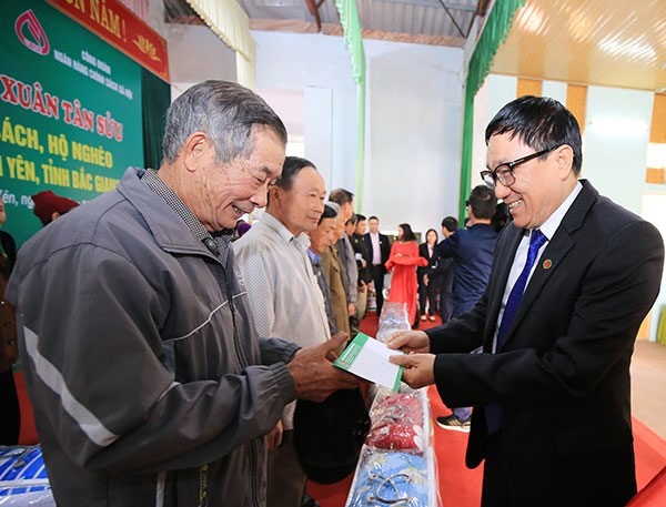 Tổng Giám đốc NHCSXH Dương Quyết Thắng tặng quà cho các gia đình có công với Cách mạng, gia đình chính sách và hộ nghèo tại xã Lam Cốt.