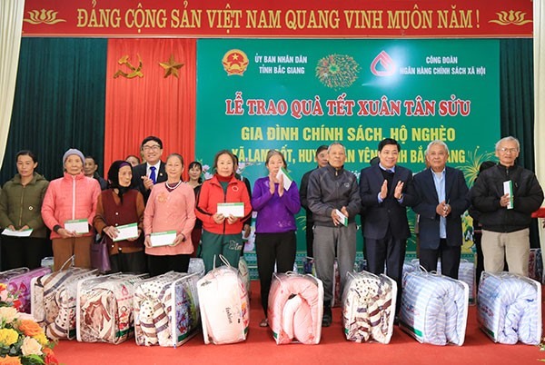 Các gia đình có công với Cách mạng, gia đình chính sách và hộ nghèo ở xã Lam Cốt nhận quà Tết từ NHCSXH.
