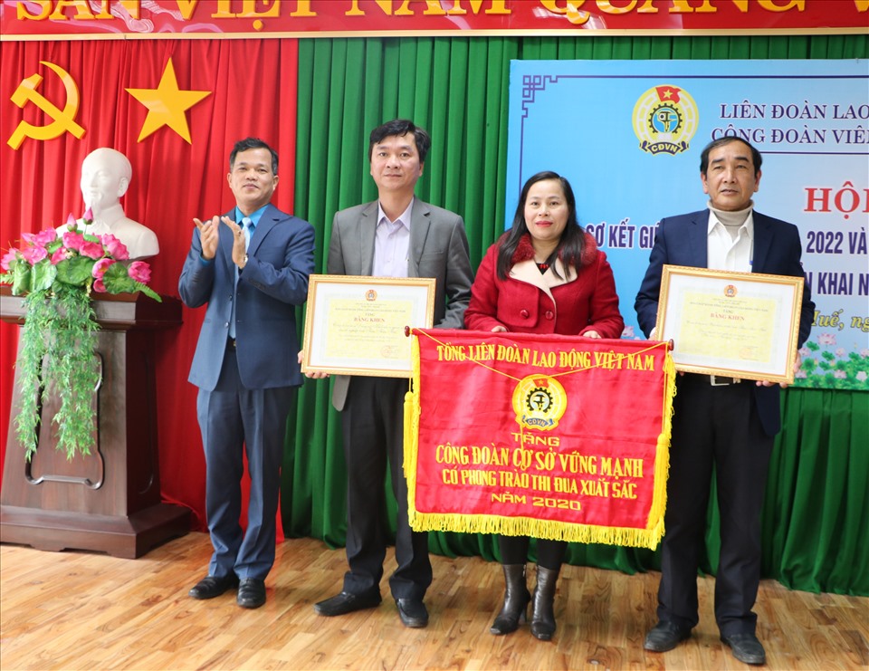 Ông Lê Minh Nhân (trái) - Chủ tịch LĐLĐ Thừa Thiên Huế trao cờ thi đua của Tổng LĐLĐ Việt Nam cho các Công đoàn cơ sở có thành tích xuất sắc. Ảnh: PĐ.