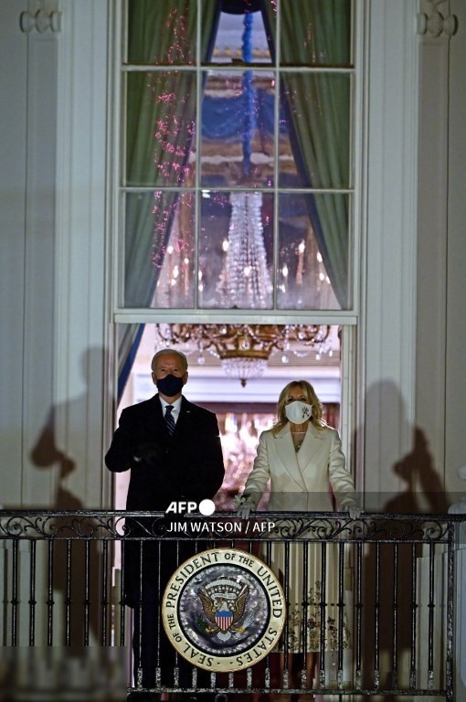 6. Tổng thống Hoa Kỳ Joe Biden (L) và Đệ nhất phu nhân Jill Biden xuất hiện trên Ban công Phòng Xanh để xem pháo hoa từ Nhà Trắng ở Washington, DC vào ngày 20 tháng 1 năm 2021.