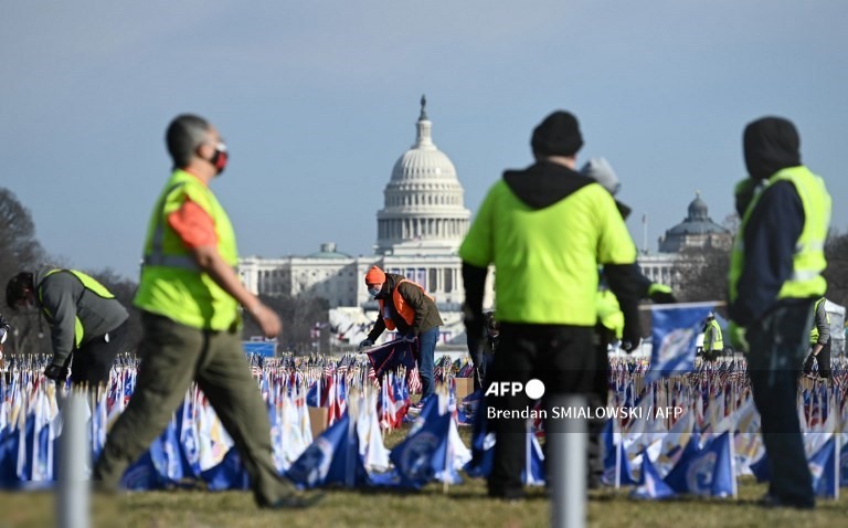 2. Mọi người thu thập các lá cờ Hoa Kỳ trang trí Trung tâm Mua sắm Quốc gia ở Washington, DC, vào ngày 21 tháng 1 năm 2021, một ngày sau lễ nhậm chức của Tổng thống Hoa Kỳ Joe Biden.