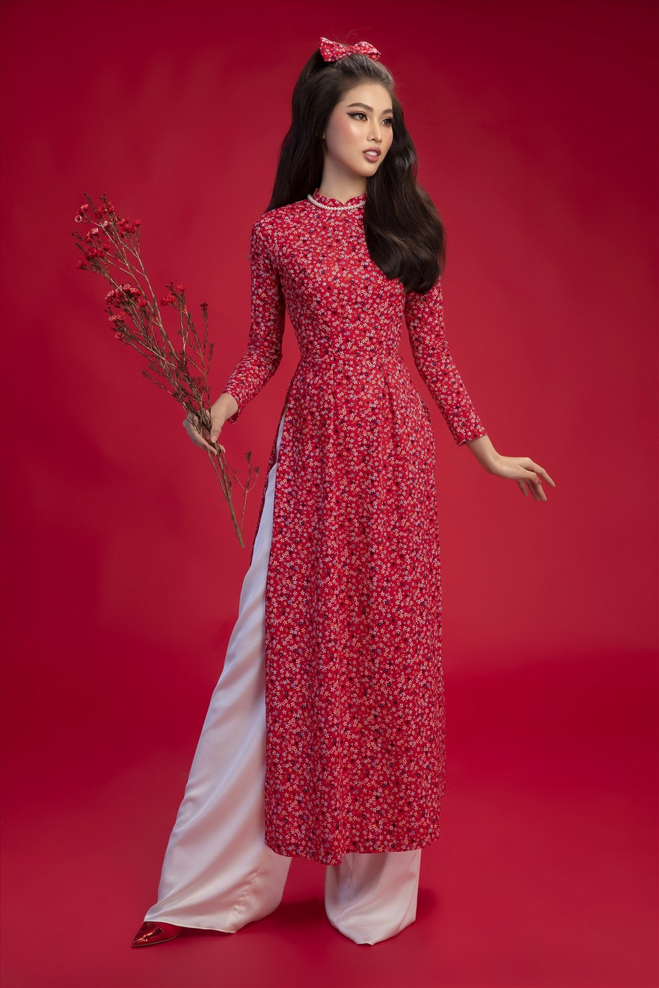 Áo dài hoa nhí đỏ phù hợp với các bạn nữ yêu thích phong cách retro của các giai nhân ngày xưa. Với trang phục này, bạn có thể để tóc xoăn lọn to giống Á hậu Ngọc Thảo hoặc cũng có thể búi cao, đánh phồng tóc và kết hợp với phụ kiện là băng đô. Ảnh: SV.