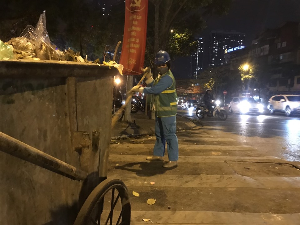 Trời đã về khuya, công nhân dọn vệ sinh môi trường vẫn gồng mình để dnj đường phố sạch đẹp trong những ngày diễn ra Đại hội Đảng XIII.