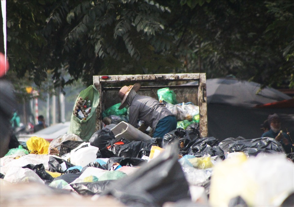 Công nhân thu dọn rác thải, tránh gây ô nhiễm môi trường.