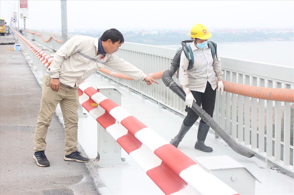 Công nhân làm sạch phần lề bộ hành trước khi trải nhựa.