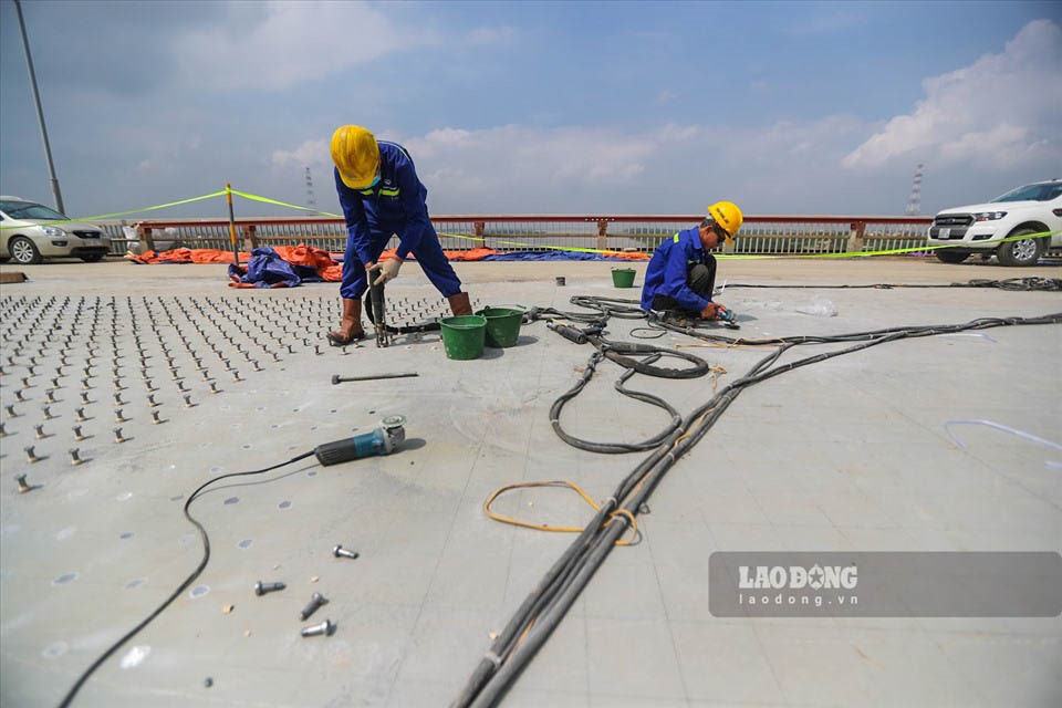 Sau hơn một tháng cào bóc và vệ sinh bề mặt cầu Thăng Long, nhà thầu bắt đầu thực hiện hàn 1,5 triệu chiếc đinh neo lên bề mặt cầu.