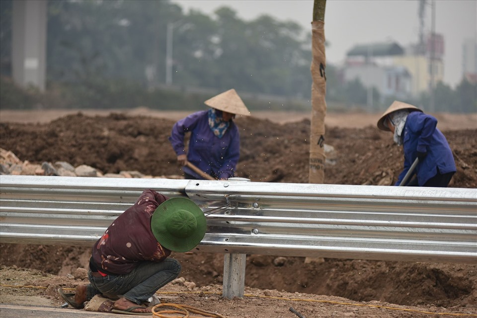 Công nhân lắp đặt hệ thống lan can tại nút giao Vành đai 3 với cao tốc Hà Nội - Hải Phòng.