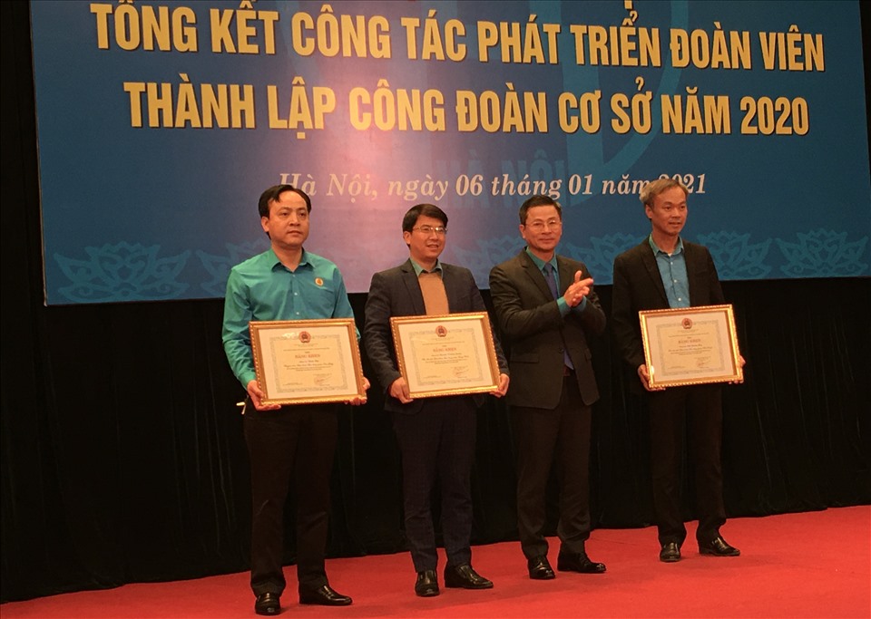 Chủ tịch Liên đoàn Lao động Thành phố Hà Nội Nguyễn Phi Thường (thứ hai từ phải sang) trao Bằng khen cho 3 cá nhân có thành tích xuất sắc. Ảnh: Hải Anh