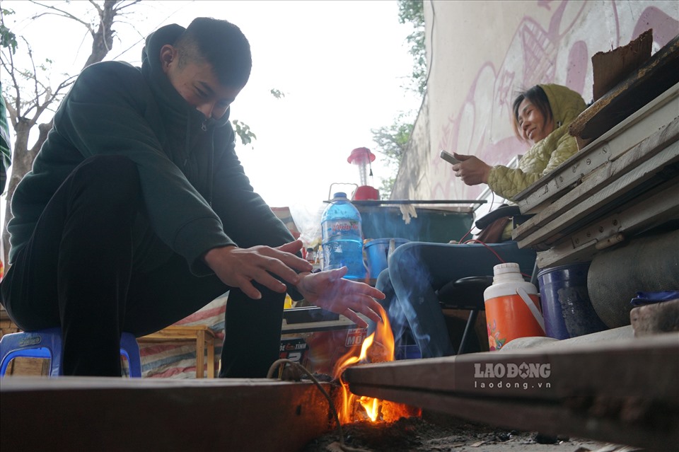 Nhóm công nhân, xe ôm công nghệ, người thu mua phế liệu quây quần sưởi ấm quanh chiếc bếp lửa bên đường.
