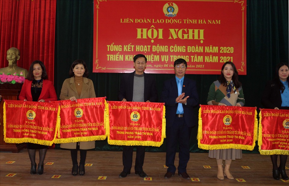 Chủ tịch LĐLĐ tỉnh Hà Nam Trịnh Văn Bừng tặng Cờ của LĐLĐ tỉnh cho các tập thể có thành tích xuất sắc trong phong trào thi đua năm 2020. Ảnh: Phúc Lộc